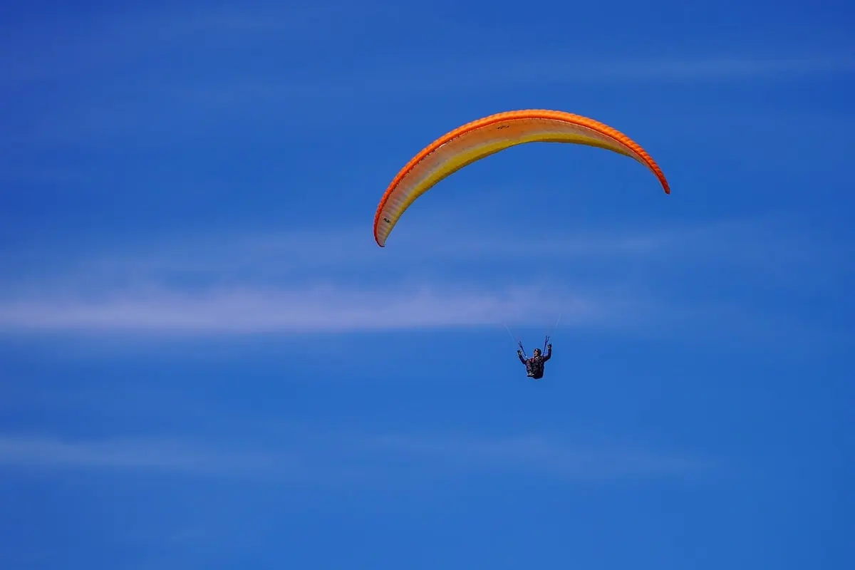 A paraglider against a clear blue sky