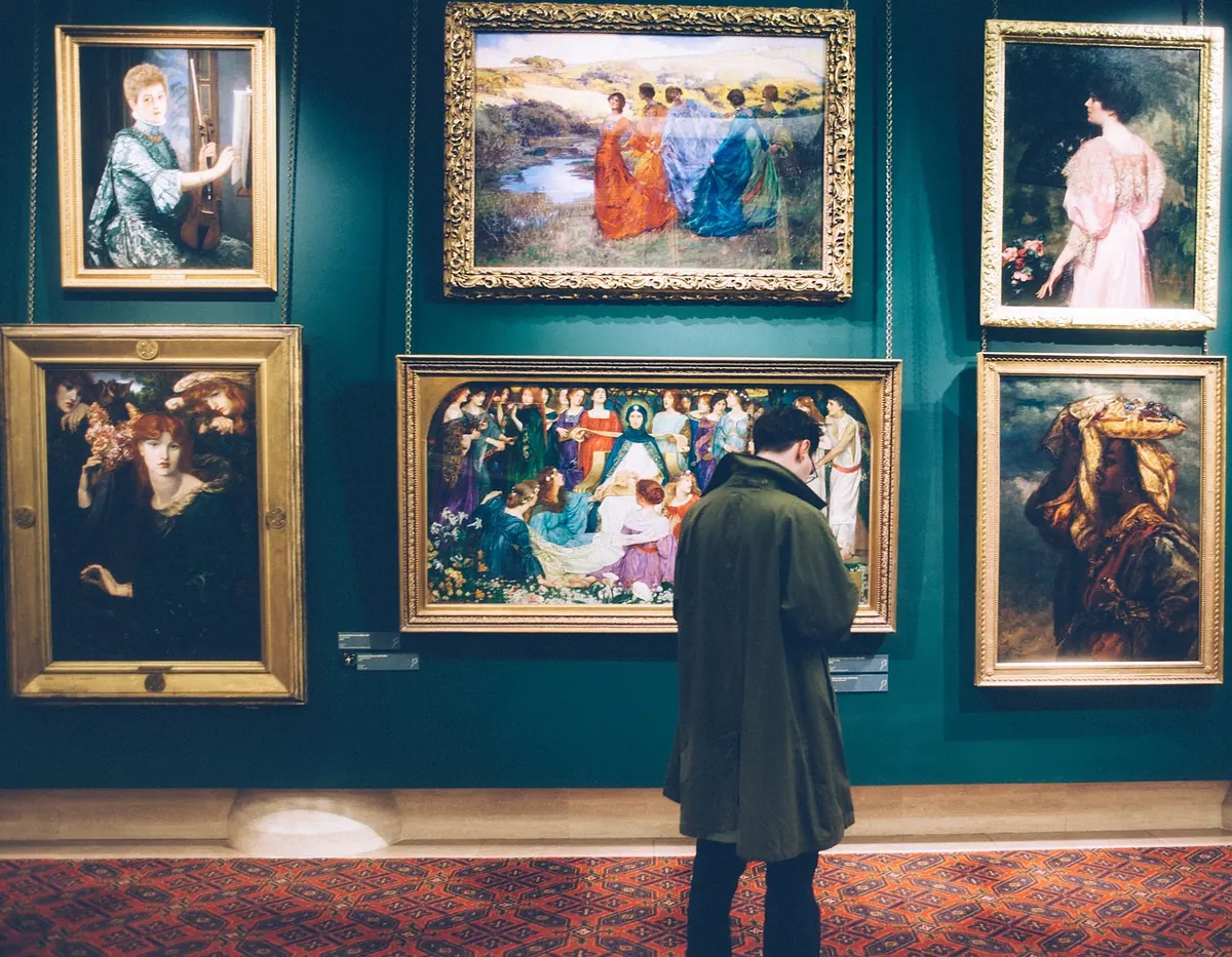 A visitor looking at paintings in a gallery
