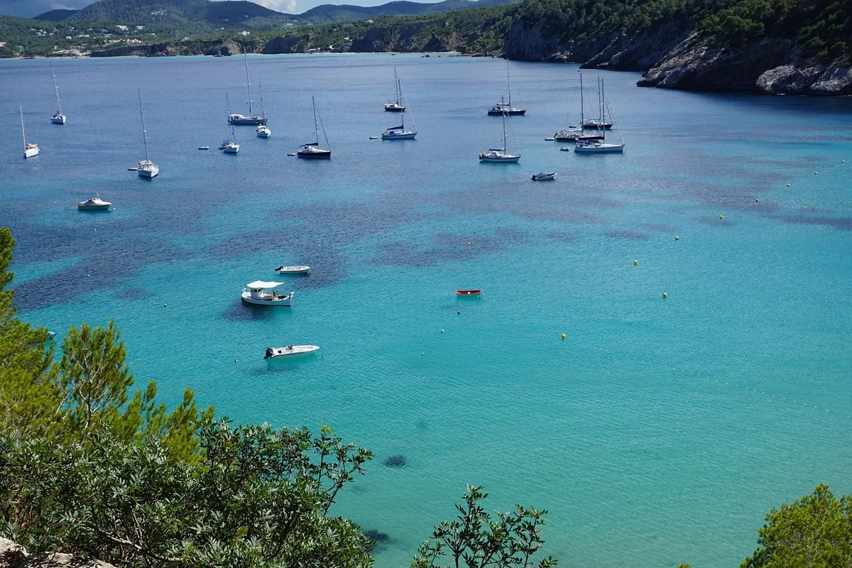 Boats moored in a turquoise Ibiza bay