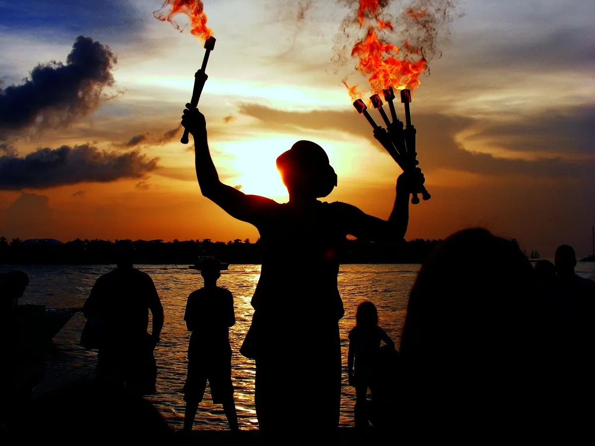 A fire juggler performing at sunset