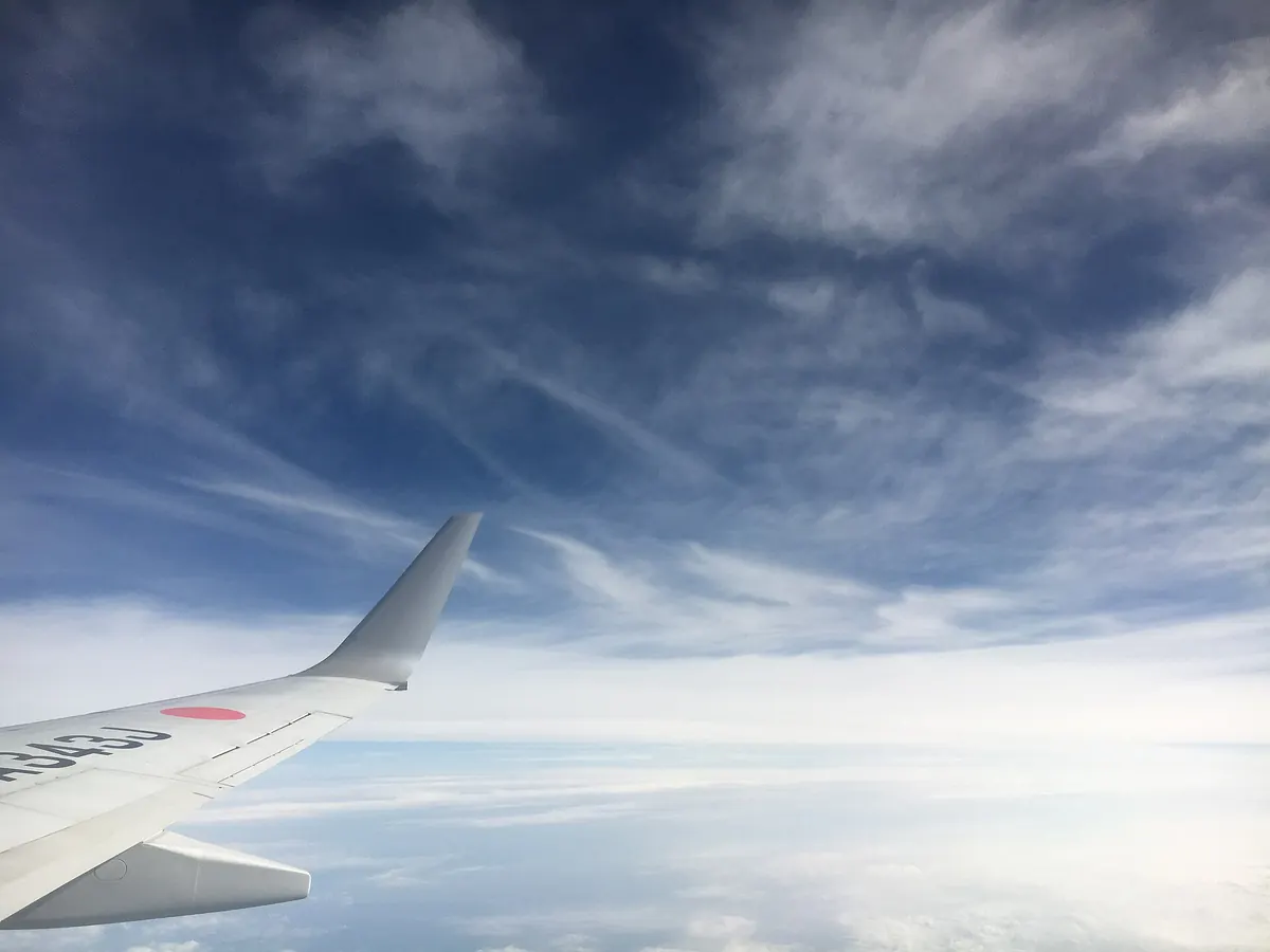 View from an airliner window above scattered clouds